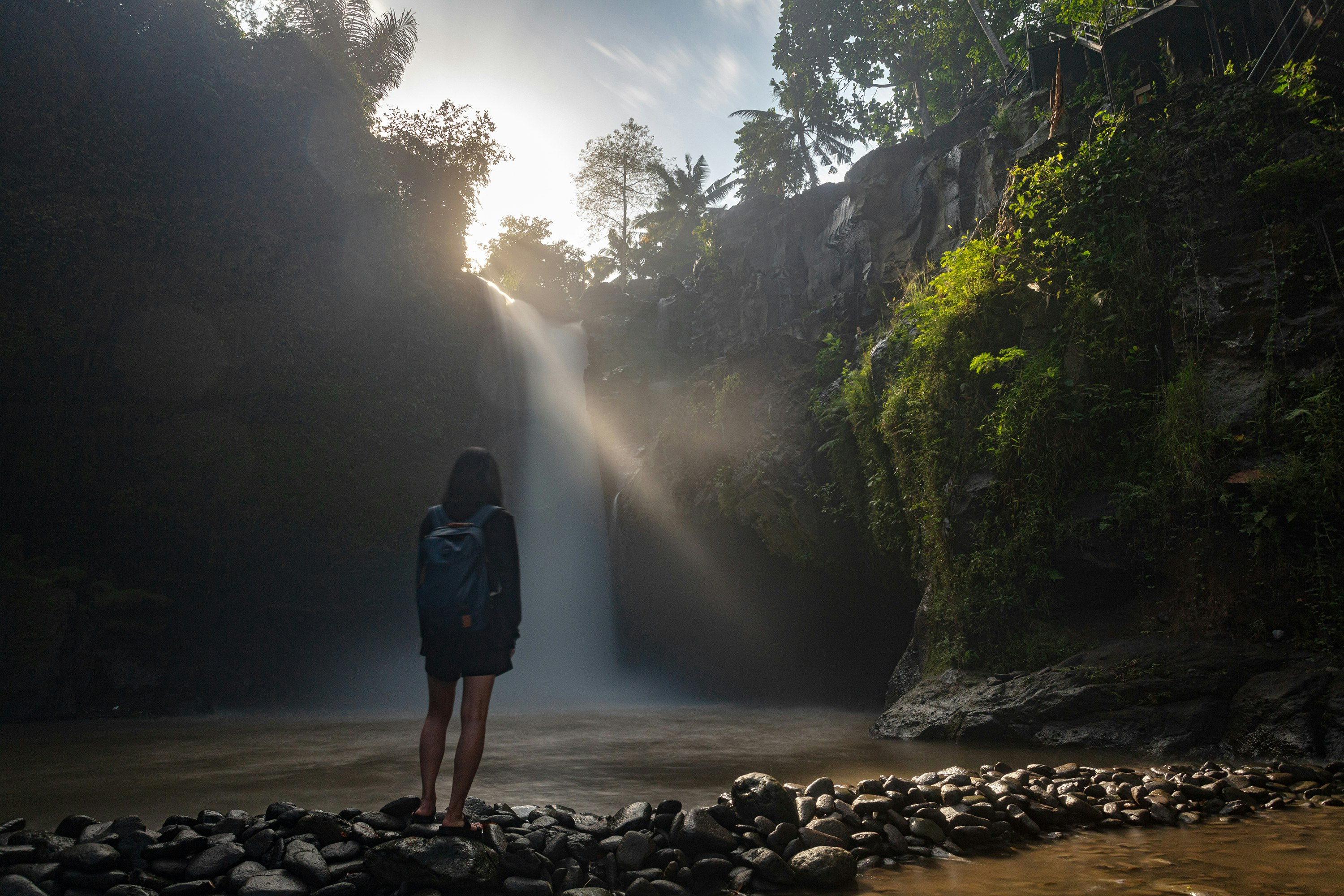 woman wearing black jacket looking at waterfalls screenshot